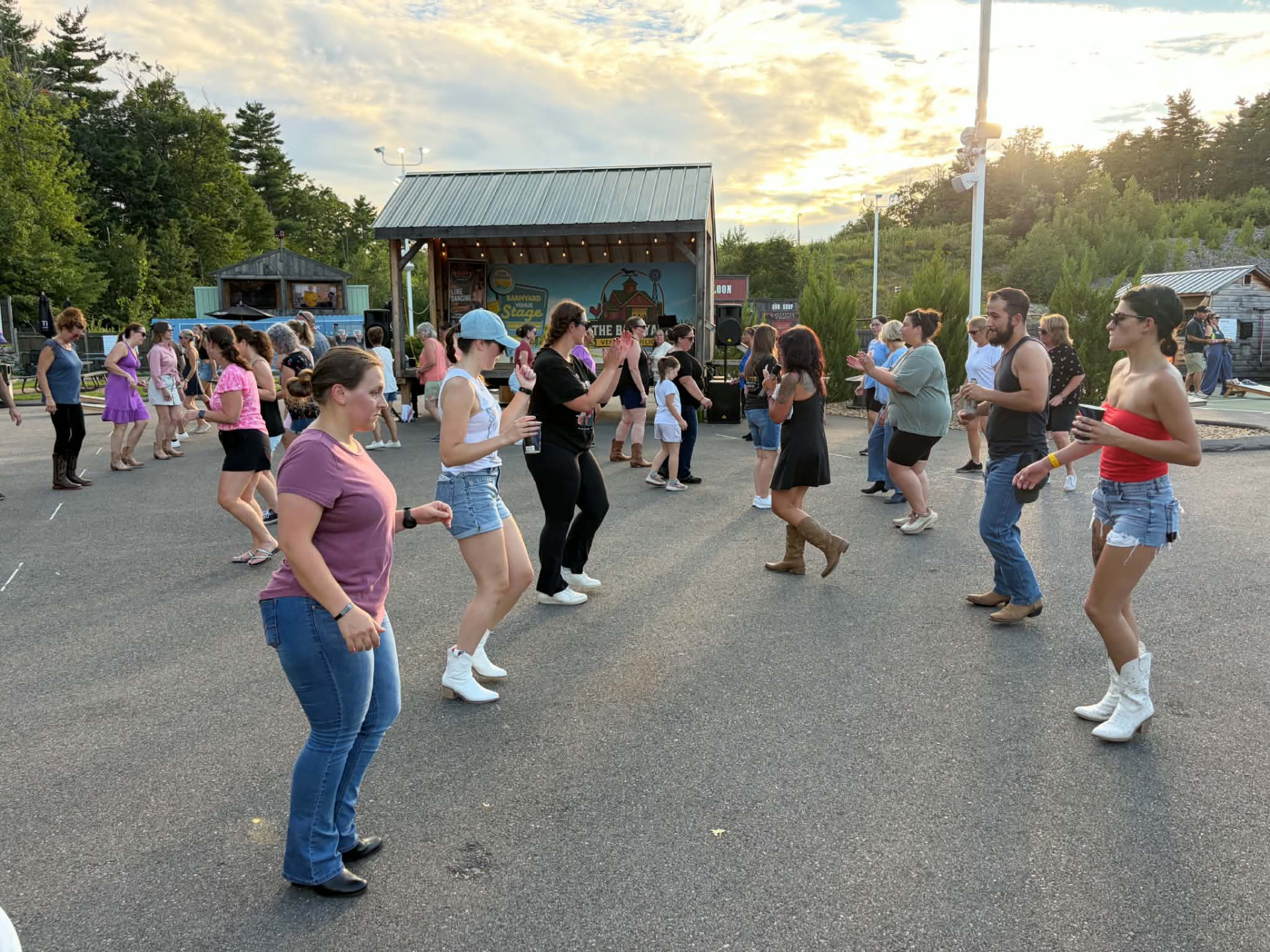 A Boots on the Ground line dance class outdoors at sunset